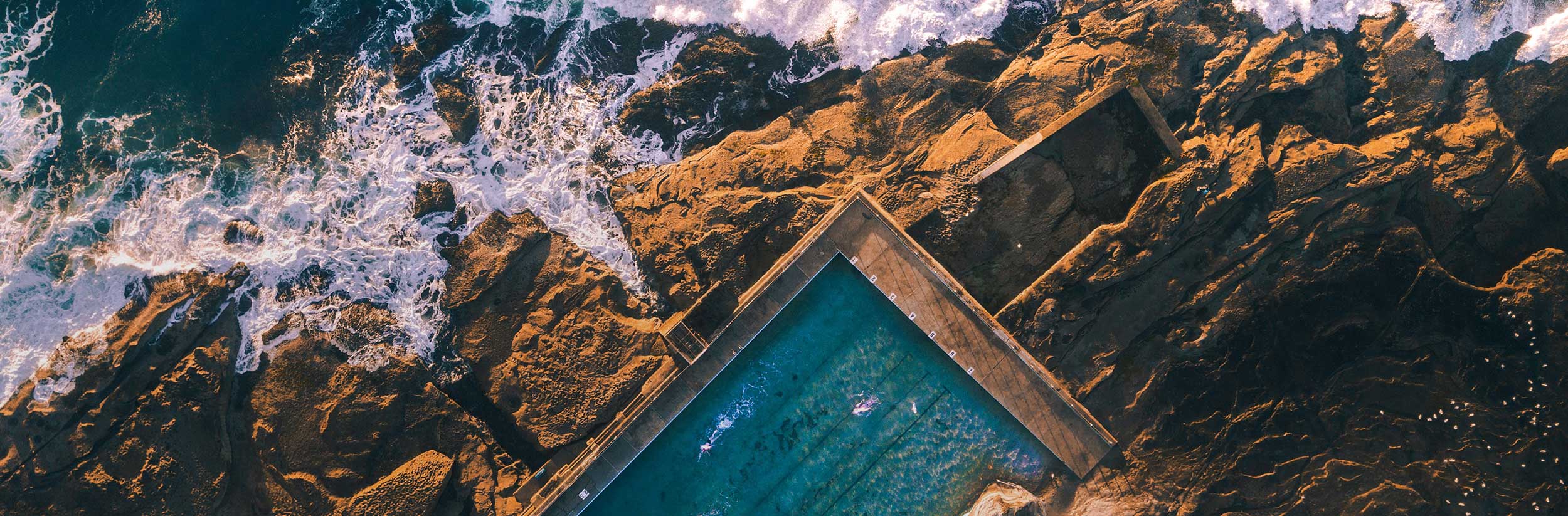 a view of mountains and sea with waves